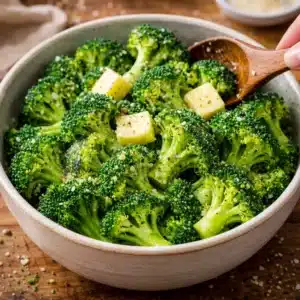 Transfer the steamed broccoli to a bowl, add butter, salt, pepper, and garlic powder, then toss gently until everything melts and coats evenly.